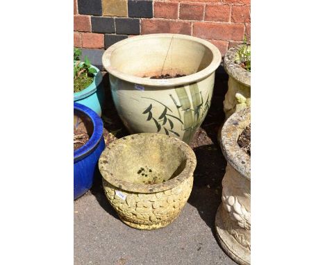 A large pottery garden planter hand painted with bamboo with a small cast concrete flower head planter
