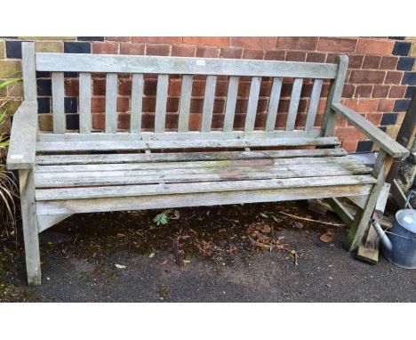A teak slatted garden bench of typical form