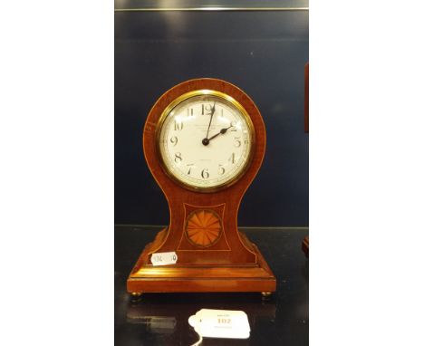 A mahogany and satinwood line and shell inlaid balloon clock having enamel dial with Arabic numerals and French movement, for