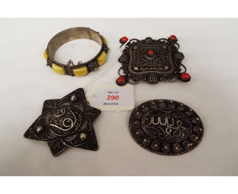 A selection of Eastern silver brooches and a bangle