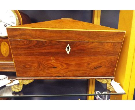 A Regency tea caddy with brass handles resting on paw feet