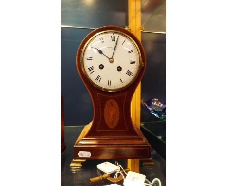 A Russell's Ltd of Liverpool mahogany cased balloon clock with satin wood line and shell inlay, resting on four brass bracket
