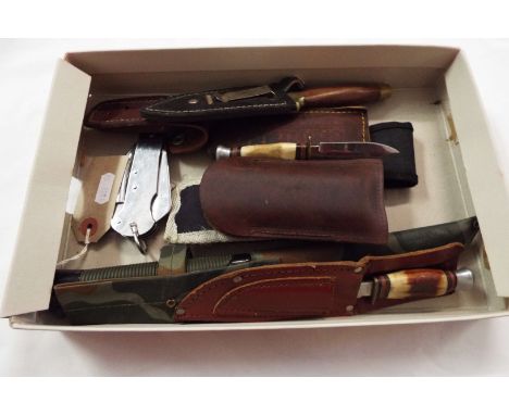 A folding British Army knife, two hunting knives and three other knives along with a sharpening stone