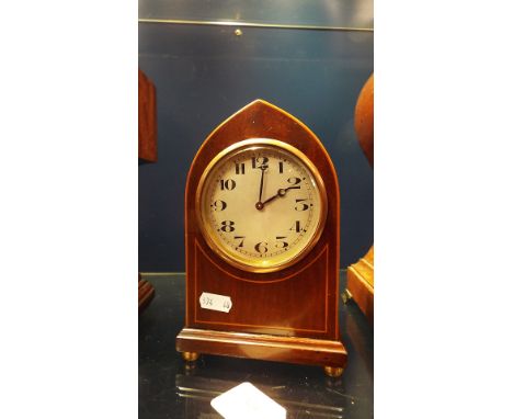 A mahogany and satinwood lined inlaid arch topped mantle clock having silvered dial and Arabic numerals with Swiss movement, 