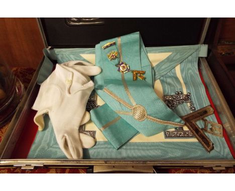 A selection of Masonic memorabilia to include apron, sash, gloves, a valuable service medallion, silver and gilt enamel medal