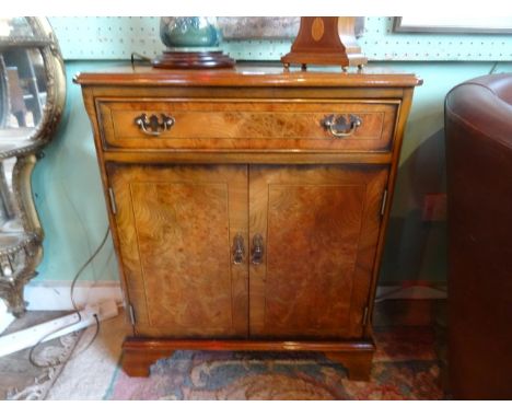 A walnut side cabinet, having single drawer over two cupboard doors on bracket feet, 20th century (60cm wide).