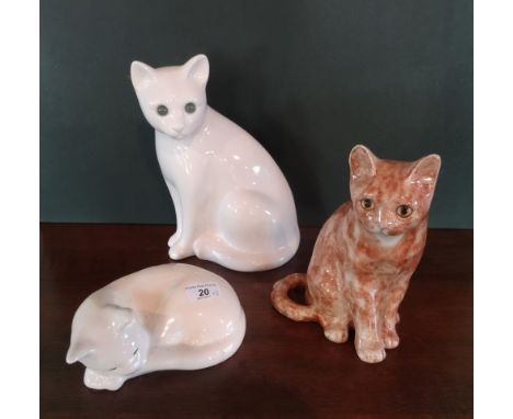 A ginger ceramic cat with glass eyes in the manner of Winstanley (22cm tall), together with two further ceramic cat models.