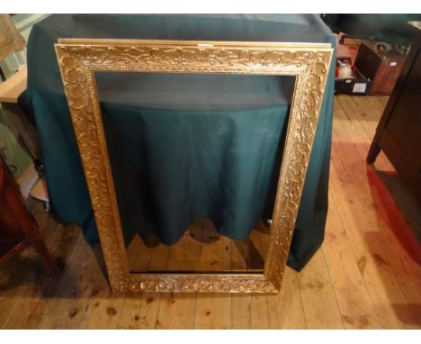 A gilt composite picture frame with moulded decoration (90cm x 67cm).