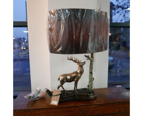 A contemporary lamp modelled as a stag by a tree, with oval shade, H.65 L.35cm 
