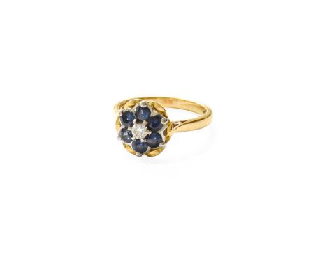 A Sapphire and Diamond Cluster Ring, of flower head form, the round brilliant cut diamond within a border of round cut sapphi