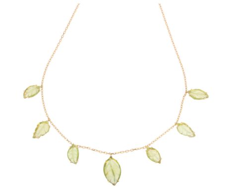 An 18ct gold peridot leaf fringe necklace, set with graduated carved peridots, on integral 18ct cable link chain, largest lea