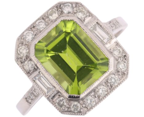 An Art Deco style platinum peridot and diamond cluster ring, rub-over set with octagonal step-cut peridot with modern round b