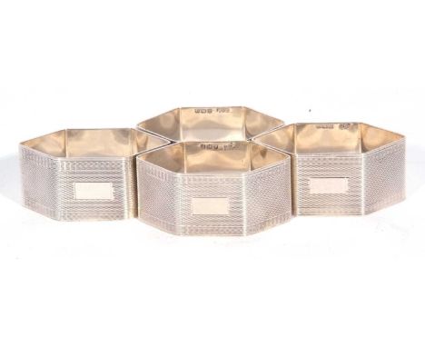 Set of four George VI napkin rings of compressed hexagonal form, all over banded engine turned decoration, each with a vacant