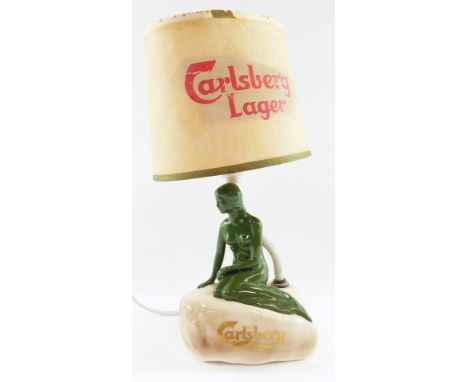 A Carlsberg pottery advertising table lamp, displaying the Little Mermaid atop the rock, with a Carlsberg Lager paper shade, 