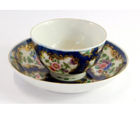 A Worcester First Period porcelain tea bowl and saucer, circa 1770, polychrome decorated with reserves of flowers against a b