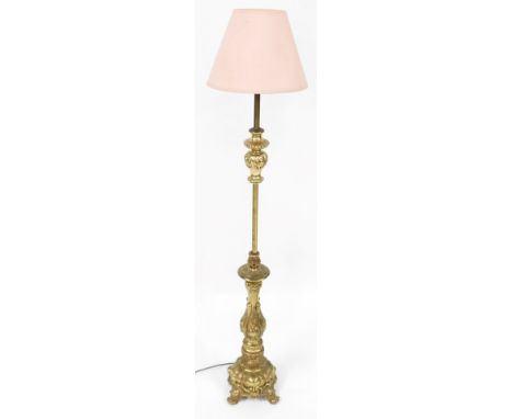 A brass standard table lamp, with rococo formed scroll supports, and pink material shade, 120cm high. 