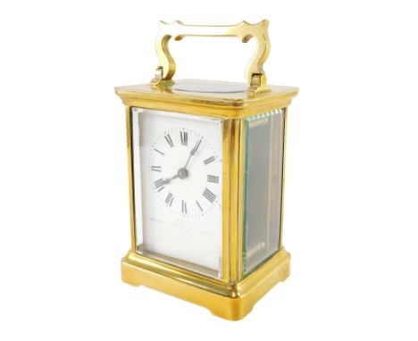 An early 20thC brass carriage clock, with rectangular white enamelled finish, with Roman numerals bearing the London Clock Co