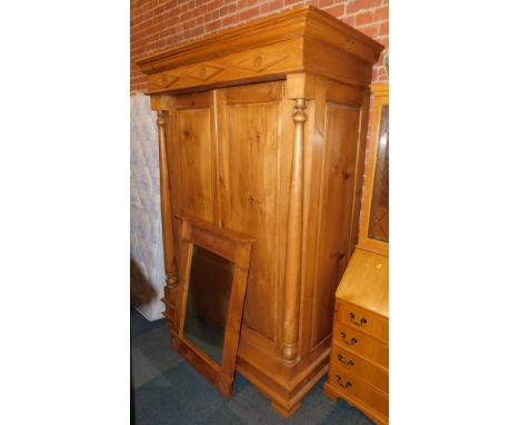 A Malaysian hardwood two door wardrobe and associated mirror, the wardrobe with cornice and two paneled diamond top with flow