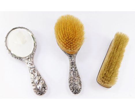 An Edward VII silver backed hairbrush, embossed with masks, birds and scrolls, Birmingham 1909, silver backed hand mirror emb