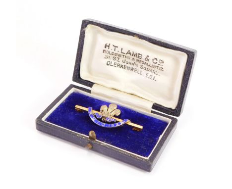 An enamel bar brooch, with central Prince of Wales feather and crown emblem bearing the inscription RMIC 1977, on a gold plat