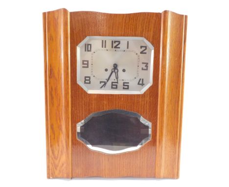 A continental mid century light oak cased wall clock, the octagonal silvered dial bearing Arabic numerals, eight day movement