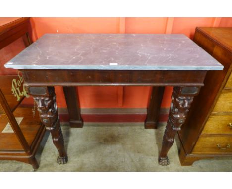 A George IV Irish mahogany console table, the rectangular grey marble top above a plain frieze, on carved lions mask legs ter