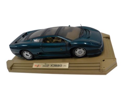 A Maisto model of a Jaguar XJ220, from 1992, on a stepped plinth, 47cm wide.