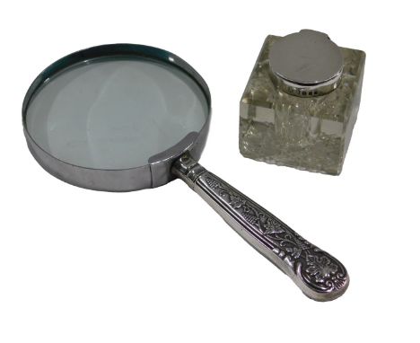 A chrome plated magnifying glass, with silver handle, decorated with grapes and vines, and an inkwell with silver lid. (2)
