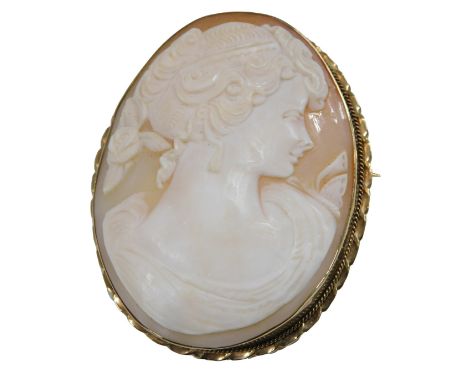 A shell cameo brooch, bust portrait of a lady, in a yellow metal mount, unmarked, 62mm high.
