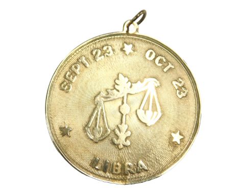 A Libra pendant, embossed with scales and Sept 23-Oct 23, stamped 14k, 4.9g.