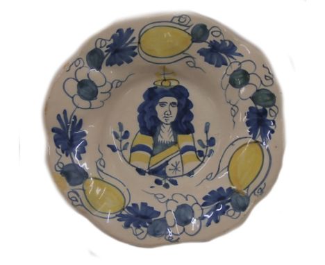 A 17thC Delft plate, decorated with a portrait of King William III of Holland, within floral borders in blue and yellow, numb