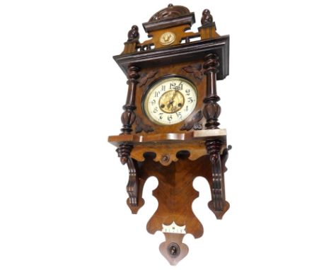 A late 19th/early 20thC Vienna wall clock, in a walnut case, the crest mounted with a gilt metal lion mask above an enamel st