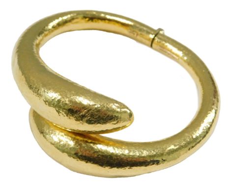 An Ilias Lalaounis gold bangle, in a textured crossover design, with a hinged mechanism, stamped 750, 51.5g.