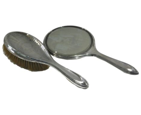 An engine turned silver dressing table mirror and a brush, early 20thC marks indistinct. (2)