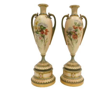 A pair of Royal Worcester blush ivory ground two handled vases, painted with flowers, on a tapering stem and domed foot, prin