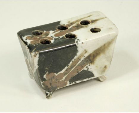 CERAMIC STAND A footed rectangular stand with six holes, possibly a pen or brush holder. Unmarked. 8.5 x 5 x 5cm.