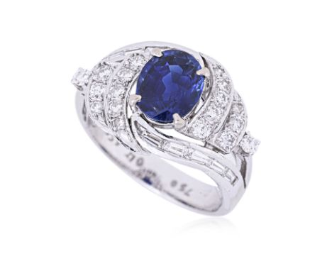 A SAPPHIRE AND DIAMOND RING
The oval blue sapphire, approximately 1.70cts (marked), in a swirl design set with baguette and r