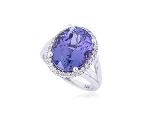 A TANZANITE AND DIAMOND RING Featuring an oval tanzanite weighing approximately 7.01 Cts, mounted on a white gold setting mar