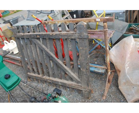 A painted oak garden gate (51" wide x 41 1/2" high) and a metal trestle.