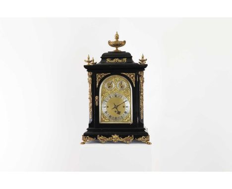 An ebonised musical bracket clock,late 19th century, with an urn finial over an arching brass dial with silvered chapter ring