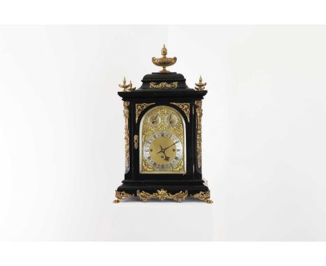 An ebonised musical bracket clock,late 19th century, with an urn finial over an arching brass dial with silvered chapter ring