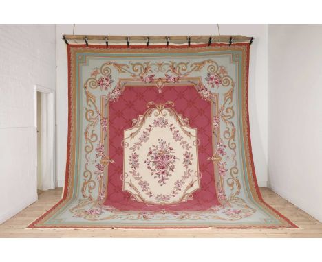 A needlepoint carpet of Aubusson design,of recent manufacture, decorated with floral garlands to a pink and blue ground,423 x