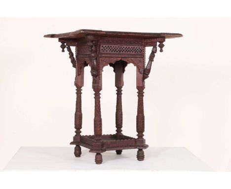 A small hardwood occasional table,early 20th century, Indian, the square top carved in relief with figural bracket supports t