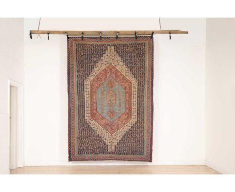 A Senneh kilim carpet,20th century, the navy field with a large central pendant, decorated all over with stylised motifs with