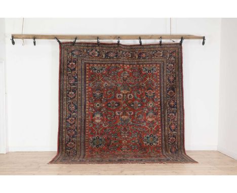 A Persian wool carpet,first half of the 20th century, Iranian, Kashan, the red field woven with scrolling Shah Abbasi motifs,