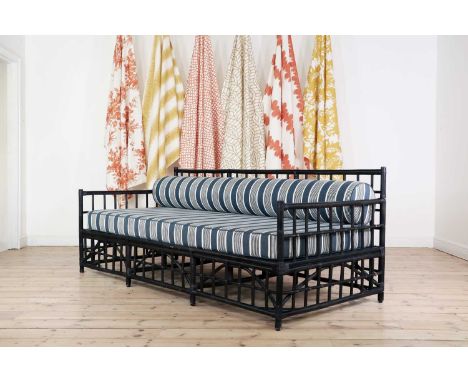 An ebonised bamboo daybed,of recent manufacture, the bolster and seat cushions upholstered in Paolo Moschino 'Elba Stripe',21