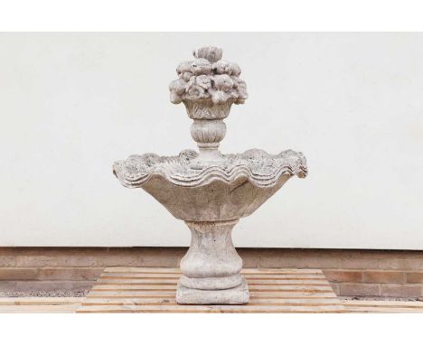 A composite stone fountain,of recent manufacture, surmounted by a basket of flowers above a wavy basin and baluster column, 8