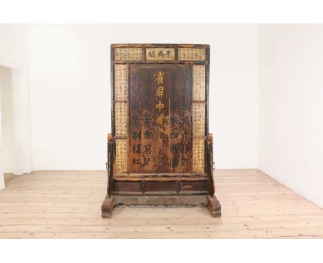An elm and bamboo screen,late 19th/early 20th century, Chinese, the panelled central section decorated to one side with Immor