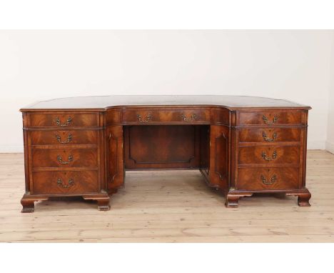 A George III-style mahogany twin-pedestal desk,first half of the 20th century, of curved shape, the top with an inset gilt-to