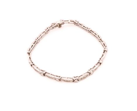 A diamond line bracelet in 9ct white gold, each elongated oval link has been calibré-set with six tapered baguette-cut diamon